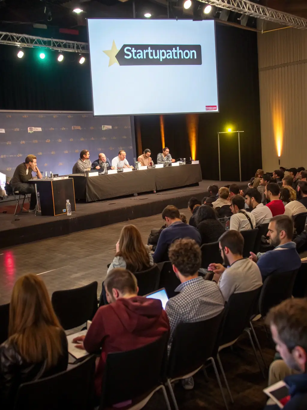 An image of the Montreal Tech Innovation Summit, featuring a startup pitch competition, with judges and audience members actively engaged.